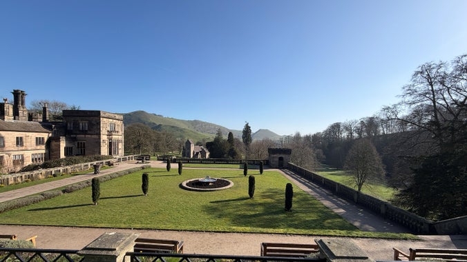 A view over Italian gardens with a flat topped cloud in the background